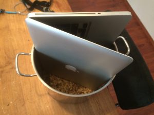 laptop in pan met rijst